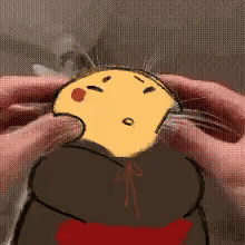 A Person Is Holding A Yellow Cartoon Character In Their Hands And Petting It . GIF