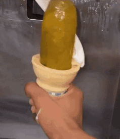 A Person Is Holding An Ice Cream Cone That Has A Pickle In It . GIF