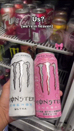 A Person Is Holding Two Cans Of Monster Energy Drinks In Front Of A Fridge GIF