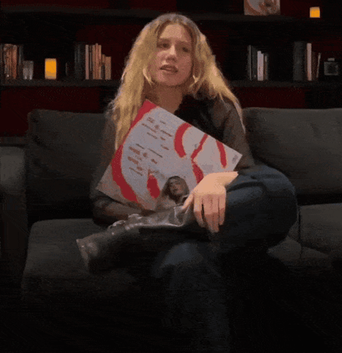 A Person Is Holding Up A Picture Of A Man With A Red S On His Chest GIF