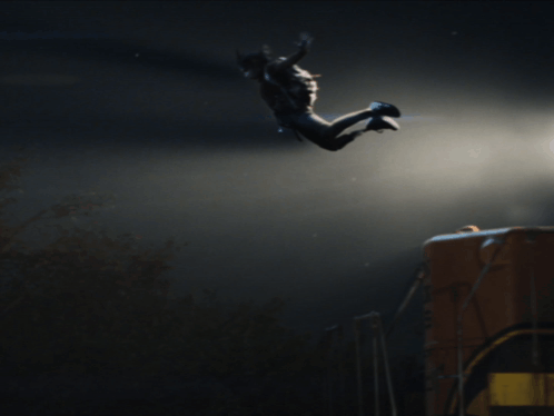 A Person Is Jumping In The Air With A Dark Background GIF