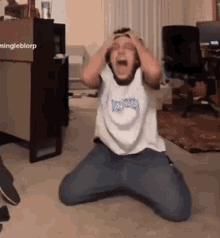 A Person Is Kneeling Down With Their Hands On Their Head . GIF