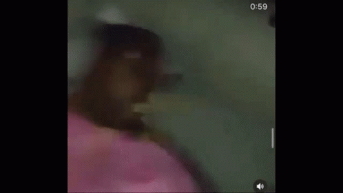 A Person Is Laying On A Bed With A Pink Blanket And Headphones . GIF