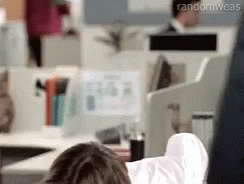 A Person Is Laying On A Desk With Their Feet Up In An Office . GIF