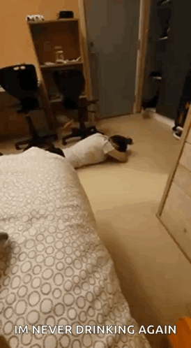 A Person Is Laying On The Floor In A Room With The Words `` Im Never Drinking Again '' Written On The Bottom . GIF