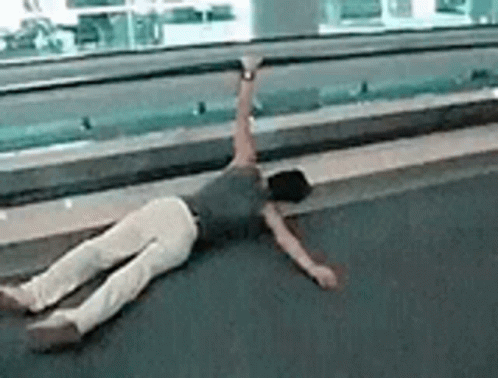 A Person Is Laying On Their Back On The Floor With Their Arms Outstretched . GIF