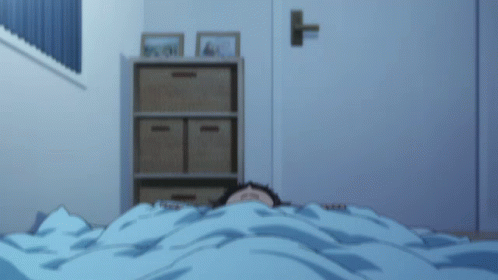 A Person Is Laying Under A Blue Blanket With Their Eyes Closed GIF
