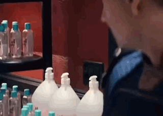 A Person Is Looking At Bottles Of Hand Sanitizer In A Store . GIF