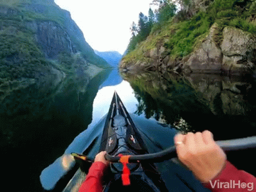 A Person Is Paddling A Kayak On A Lake With The Words Viralhog Below Them GIF
