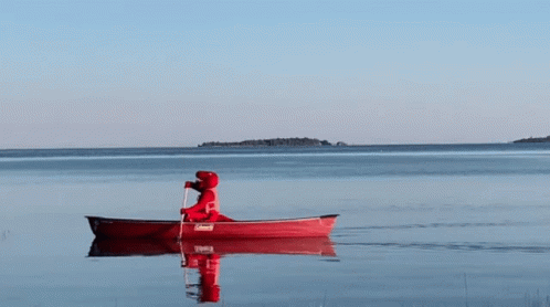 A Person Is Paddling A Red Coleman Canoe In The Water GIF