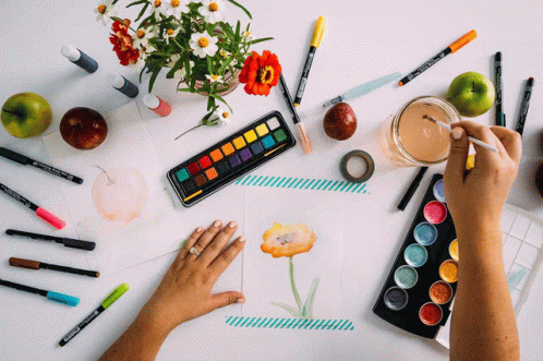 A Person Is Painting A Flower On A Piece Of Paper With A Palette Of Watercolors GIF