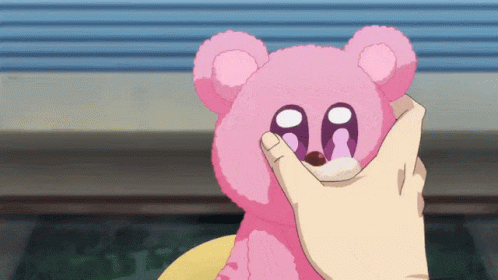 A Person Is Petting A Pink Teddy Bear With The Letter Aa On Its Eyes GIF