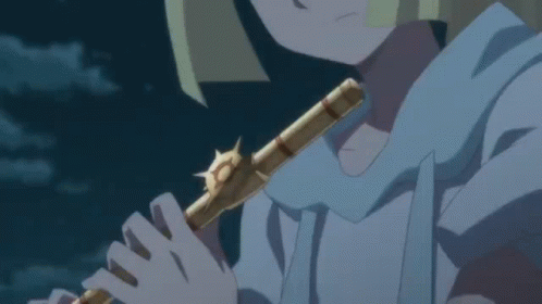 A Person Is Playing A Flute In A Dark Room GIF