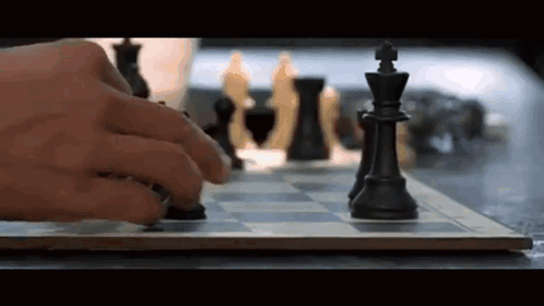 A Person Is Playing A Game Of Chess And Moving A Piece On The Board . GIF