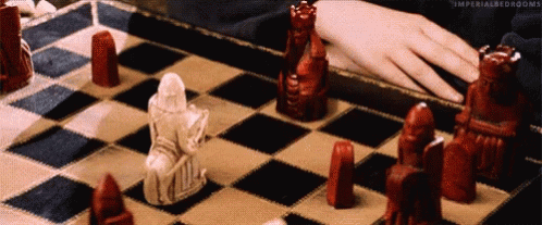 A Person Is Playing A Game Of Chess With Red And White Chess Pieces . GIF