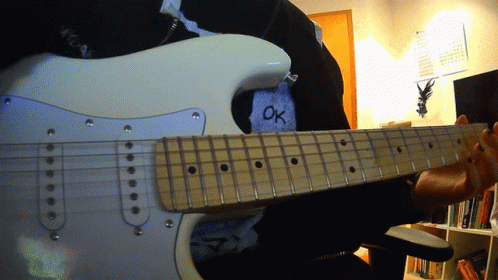 a person is playing an electric guitar with the word ok written on their shirt