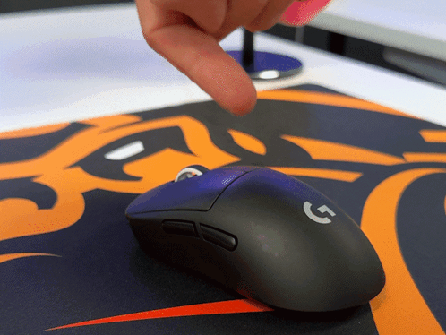 A Person Is Pointing At A Black Logitech Mouse GIF