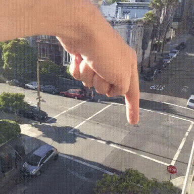 A Person Is Pointing At A Stop Sign GIF