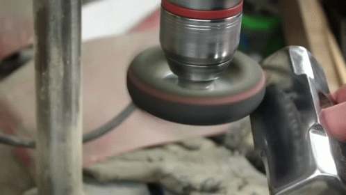 A Person Is Polishing A Piece Of Metal With A Polisher GIF
