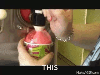 A Person Is Pouring A Drink Into A Cup And The Words This Are On The Bottom Of The Image . GIF