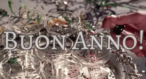 A Person Is Pouring Champagne Into A Pyramid Of Champagne Glasses With The Words Buon Anno In The Background . GIF