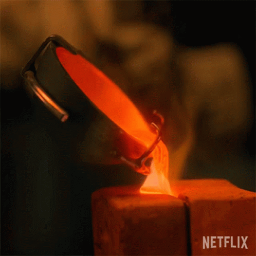 A Person Is Pouring Molten Metal Into A Piece Of Wood . GIF