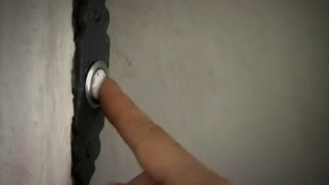 A Person Is Pressing A Doorbell With Their Finger On A Wall . GIF