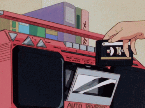 A Person Is Putting A Cassette Tape Into An Auto Reverse Cassette Player GIF