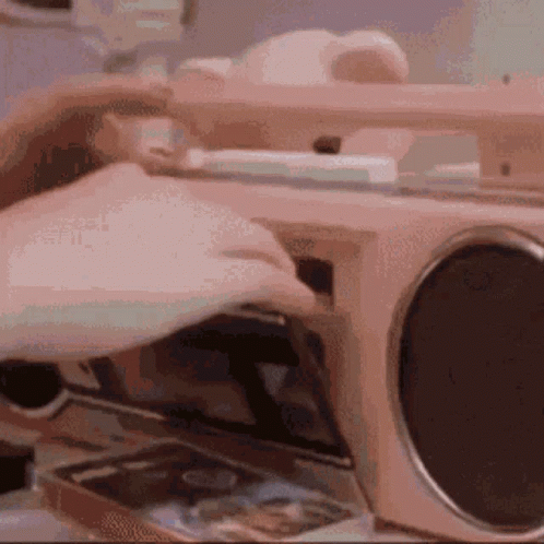 A Person Is Putting A Cd Into A Radio . GIF