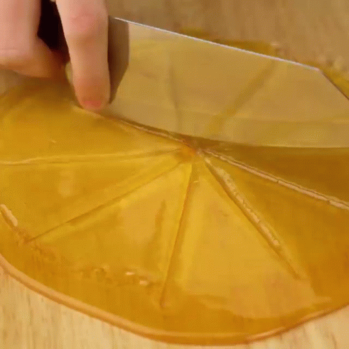 A Person Is Putting A Doughnut On Top Of A Chocolate Cake On A Wooden Cutting Board . GIF