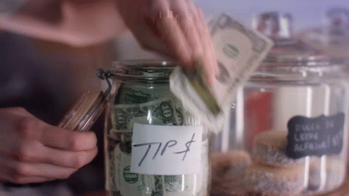A Person Is Putting Money Into A Jar Labeled Tip $ GIF