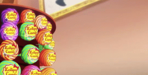 A Person Is Reaching For A Lollipop In A Display Of Lollipop Candy GIF