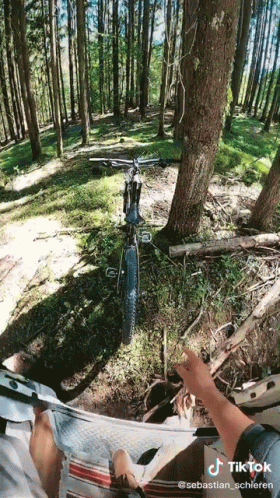 A Person Is Riding A Bike In The Woods With A Tiktok Watermark On The Bottom GIF
