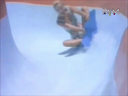 A Person Is Riding A Blue Board Down A Water Slide With The Letters Mm Visible GIF
