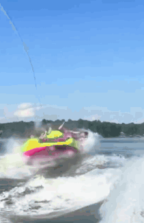 A Person Is Riding A Colorful Raft In The Water GIF