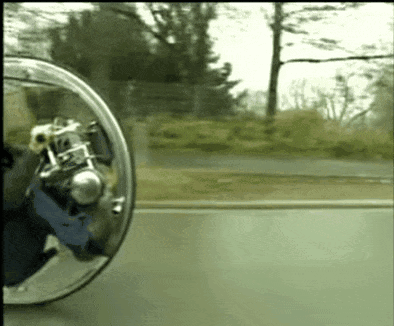 A Person Is Riding A Motorcycle On A Road With A Rear View Mirror Behind Them GIF