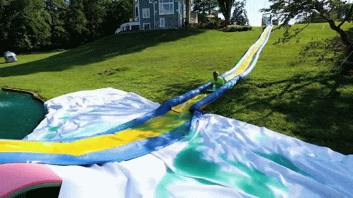 A Person Is Riding Down A Giant Water Slide GIF