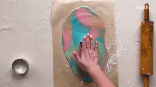 A Person Is Rolling Out Dough With A Rolling Pin GIF