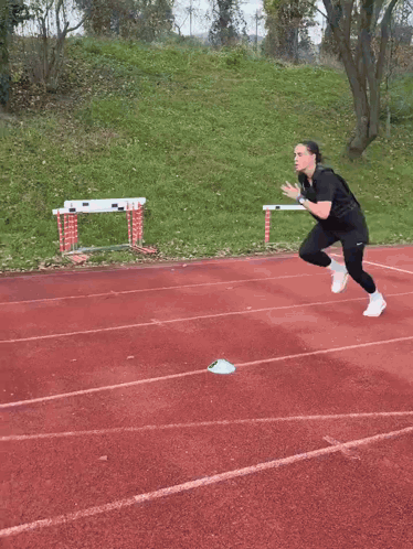 A Person Is Running On A Track With A Stadium In The Background GIF