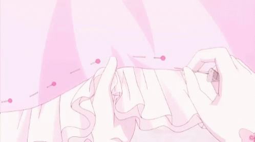 A Person Is Sewing A Pink Dress With A Pink Ribbon . GIF