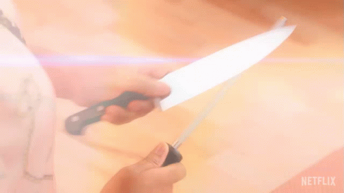 a person is sharpening a knife with a netflix logo behind them