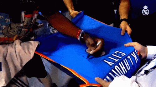 A Person Is Signing A Blue Oklahoma City Jersey GIF