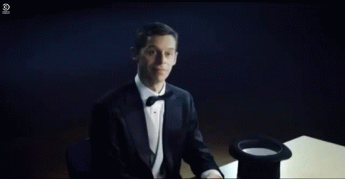 A Person Is Sitting At A Table With A Hat On And Smoke Coming Out Of It . GIF
