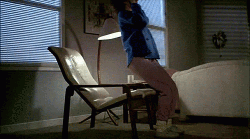 A Person Is Sitting In A Chair In A Living Room GIF