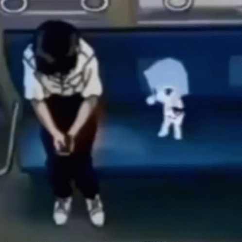 A Person Is Sitting On A Blue Couch With A Skeleton On The Back Of It . GIF