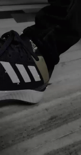 A Person Is Sitting On A Couch Wearing Adidas Shoes GIF