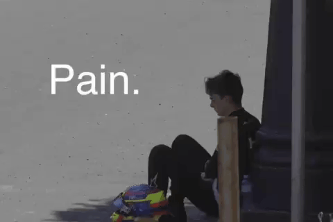 A Person Is Sitting On The Ground With A Helmet On Their Head And The Word Pain Written Above Them . GIF
