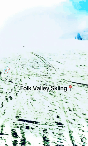 A Person Is Skiing Down A Snow Covered Slope With The Words Folk Valley Skiing Below Them GIF
