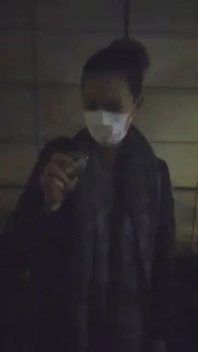 A Person Is Standing In A Dark Room With A Bright Light Coming From Behind Them GIF