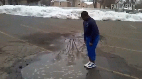 A Person Is Standing In A Puddle Of Water In A Parking Lot With Failarmy Written On The Bottom GIF